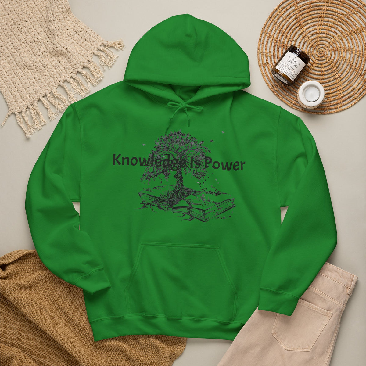 An Irish green pullover hoodie with a kangaroo pocket and blue drawstrings, featuring a black graphic of a tree growing from stacked books with the words 'Knowledge is Power.' 